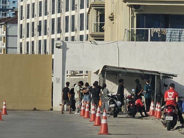 배달원들이 16일 오후 캄보디아 시아누크빌의 한 신축 범죄단지 출입구 앞에 줄을 서 있다. 이곳은 경비가 삼엄해지면서 신원 확인을 받은 사람들만 출입이 가능했다. 시아누크빌 범죄단지 곳곳에선 조직원들이 현지 경찰 단속을 피해 도주하는 상황이 벌어지고 있었다.