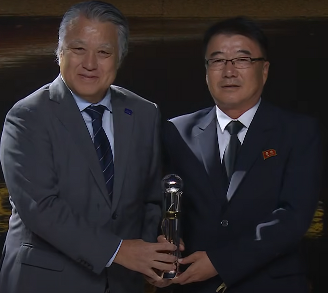 북한 여자 20세 이하팀 리성호 감독(오른쪽)이 17일 AFC 올해의 남자 감독상을 받은 뒤 기념 사진을 찍고 있다. AFC 화면 캡처
