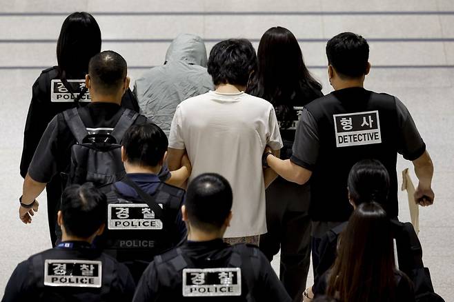 캄보디아 온라인 사기에 가담해 구금된 한국인들이 18일 오전 인천국제공항 제2터미널을 통해 송환되고 있다. 이날 송환에는 경찰 호송조 190여명이 투입됐다. 사진공동취재단