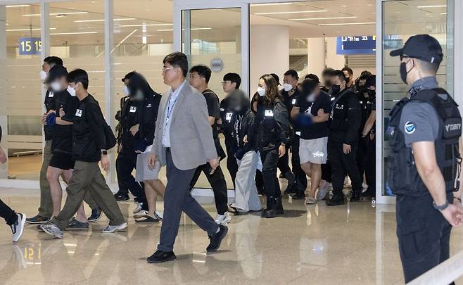 캄보디아 온라인 사기에 가담해 구금된 한국인들이 18일 오전 인천국제공항 제2터미널을 통해 송환되고 있다. 이날 송환에는 경찰 호송조 190여명이 투입됐다. 사진공동취재단