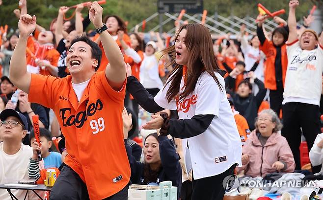 기뻐하는 한화 팬들 (대전=연합뉴스) 강수환 기자 = 18일 오후 대전 국립중앙과학관 꿈이광장에서 대전시민들이 2025 KBO 프로야구 포스트시즌 플레이오프 1차전 삼성 라이온즈와 한화 이글스의 경기를 관람하고 있다. 6회말 2사 2, 3루 때 한화 채은성이 역전포를 쏘아 올리자 팬들이 환호하고 있다. 2025.10.18 swan@yna.co.kr