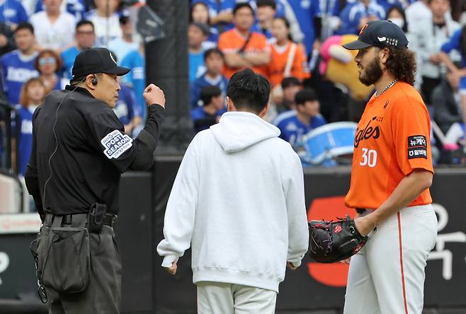 <yonhap photo-4768=""> 18일 플레이오프 1차전에서 폰세의 투구 인터벌을 지적하는 주심. 연합뉴스</yonhap>