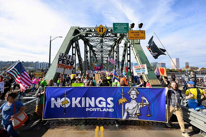 포틀랜드 호손 다리 행진하는 시위 참가자들 18일(현지시간) 미국 오리건주 포틀랜드에서 열린 ‘노 킹스’ 시위에서 참가자들이 호손 다리를 건너 행진하고 있다. AFP연합뉴스
