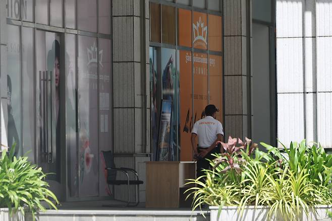 캄보디아에서 한국인 납치ㆍ감금 등 조직범죄피해가 잇따라 발생하면서 정부가 범죄조직을 대상으로 금융 제재를 검토하고 있는 가운데 19일 프놈펜 프린스그룹 본사에 경비직원이 근무하고 있다.  19일 금융당국에 따르면 금융위원회 산하 금융정보분석원(FIU)은 캄보디아 범죄 관련자를 금융거래 제한 대상자로 지정하는 방안을 검토 중이다. 유력 제재 대상으로 캄보디아 프놈펜의 ‘프린스 그룹’과 금융서비스 기업 ‘후이원 그룹(Huione Group)’ 등이 거론된다. [연합]