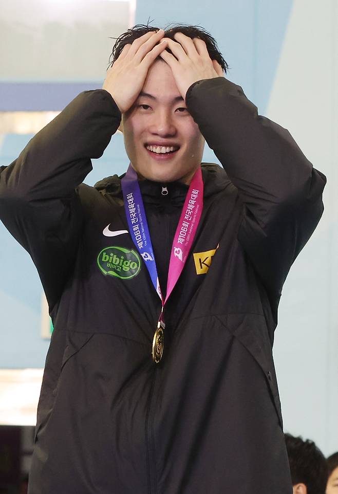 황선우(강원도청)가 20일 오후 부산 사직실내수영장에서 열린 제106회 전국체육대회 수영 남자 일반부 자유형 200m 결승 시상식에서 금메달을 목에 걸고 기뻐하고 있다. 사진 | 부산=연합뉴스