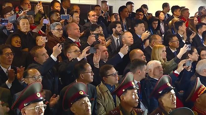 지난 10일 평양 김일성광장에서 열린 북한 조선노동당 창건 80주년 경축 열병식에서 외국인들이 스마트폰을 들고 행사를 촬영하고 있다. 조선중앙TV 캡처