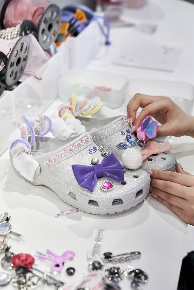 지비츠 참과 DIY 소재로 꾸미고 있는 클래식 글리터 클로그 모습 [크록스 제공]