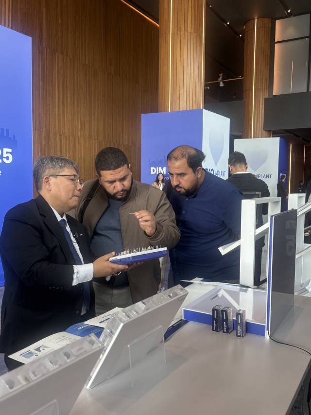 김홍(왼쪽) 디오 PM팀 본부장이 18일(현지 시간) DIM2025 참석자에게 제품에 대해 설명하고 있다. 이정민 기자