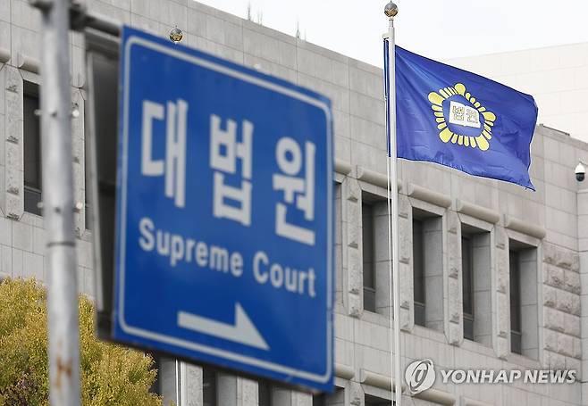 휘날리는 대법원 앞 깃발 (서울=연합뉴스) 김성민 기자 = 더불어민주당 사법개혁특별위원회가 20일 현행 14명인 대법관을 26명으로 증원하는 사법개혁안을 발표했다. 
    이날 서울 서초구 대법원에 법원 깃발이 휘날리고 있다. 2025.10.20 ksm7976@yna.co.kr