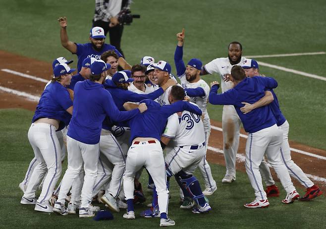 토론토 선수들이 월드시리즈 진출을 확정한 뒤 서로 얼싸안으며 기쁨을 만끽하고 있다. UPI연합뉴스