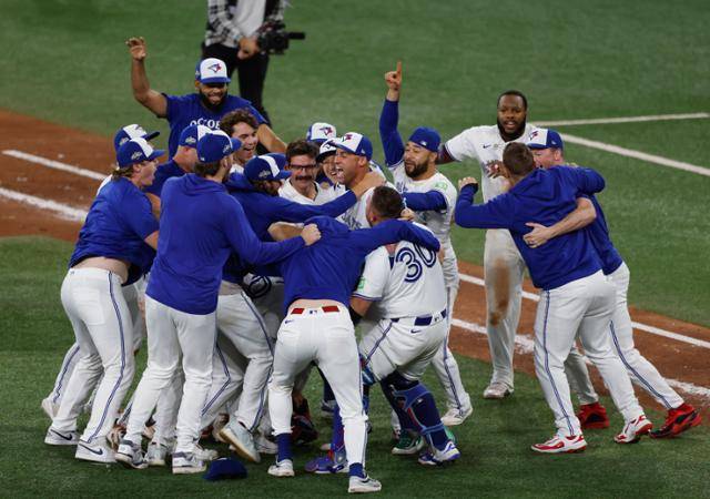 토론토 선수들이 21일 캐나다 온타리오주 토론토 로저스 센터에서 열린 2025 MLB 포스트시즌 아메리칸리그 챔피언십시리즈 7차전에서 시애틀에 4-3 역전승을 거두고 월드시리즈 진출을 확정한 뒤 환호하고 있다. 토론토=UPI 연합뉴스