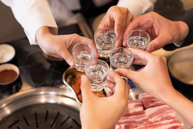People drink soju at a Korean barbeque joint [GETTY IMAGES BANK]