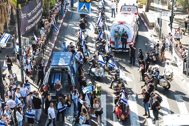 지난 7일(현지시간) 하마스의 치명적인 공격 당시 가족을 지키다 사망한 인질 로넨 엥겔의 관 주위에 사람들이 모여 있는 모습이 보인다. [로이터]