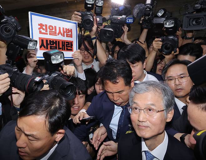 조희대 대법원장이 10월13일 서울 여의도 국회에서 열린 대법원 등에 대한 법제사법위원회 국정감사에서 정회가 선언되자 법사위 회의실을 나서고 있다. 왼쪽 위는 조 대법원장의 이석에 반대하며 무소속 최혁진 의원이 든 규탄 팻말 ⓒ 연합뉴스