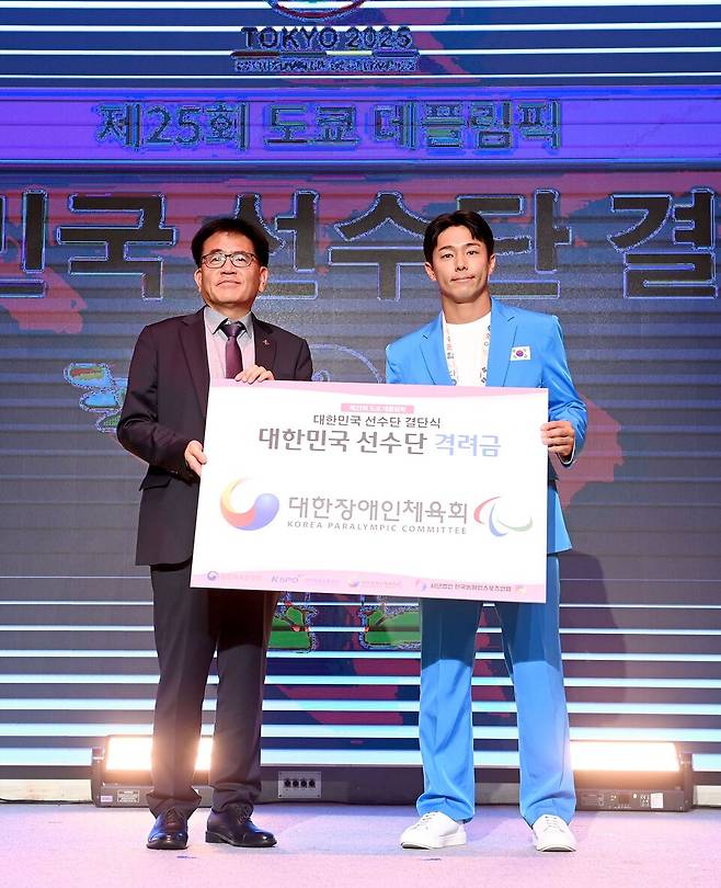 22일 올림픽파크텔 올림피아홀에서 개최된 2025 도쿄 데플림픽 대한민국 선수단 결단식에서 대한장애인체육회 이희룡 사무총장이 이덕희 선수에게 격려금을 전달하고 있다. (사진/대한장애인체육회)