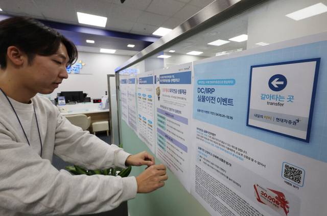 서울의 한 증권사 영업점에서 관계자가 퇴직연금 갈아타기 가능 관련 홍보물을 부착하는 모습. [연합뉴스]