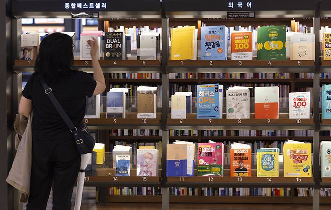 서울 종로구 교보문고 광화문점을 찾은 시민이 베스트셀러를 고르고 있다.[연합]