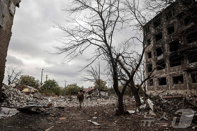 지난 12일(현지시간) 우크라이나군이 촬영해 14일에 공개한 사진에서 한 우크라이나 군인이 도네츠크 지역 코스탸티니우카의 최전선 마을에 있는 파괴된 건물 안뜰의 잔해 사이를 걷고 있다. 2025.10.12. ⓒ AFP=뉴스1 ⓒ News1 이정환 기자