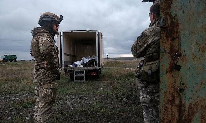 21일 우크라이나 회복 그룹 회원들이 우크라이나 돈바스 전선에서 싸우다 사망한 러시아 병사들의 신원을 확인하는 작업을 하고 있다. EPA 연합뉴스