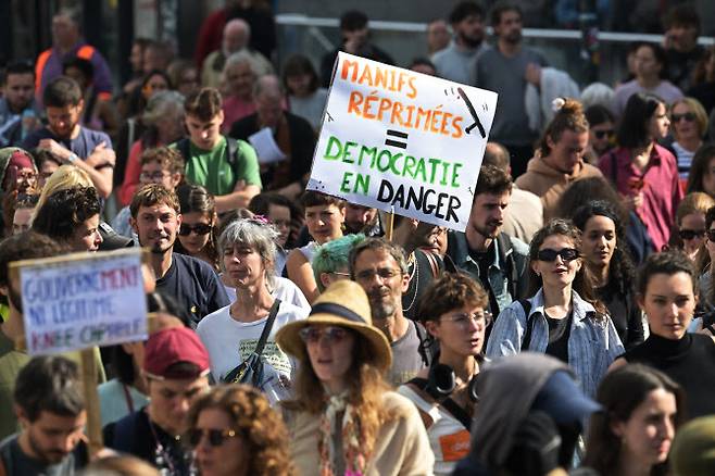 지난 2일(현지시간) 프랑스 8대 노동조합이 주도한 전국 총파업의 일환으로 렌에서 열린 시위현장. 한 참가자가 ‘시위 탄압 = 민주주의 위기’라고 적힌 팻말을 들고 있다. [AFP]