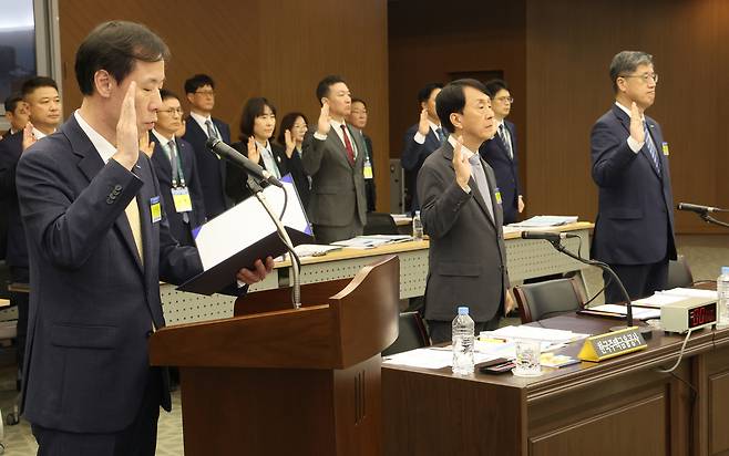 정정훈(왼쪽) 한국자산관리공사 사장이 23일 부산 남구 부산국제금융센터(BIFC)에서 열린 국회 정무위원회의 주택금융공사, 자산관리공사, 신용보증기금에 대한 국정감사에서 증인선서를 하고 있다. [연합]