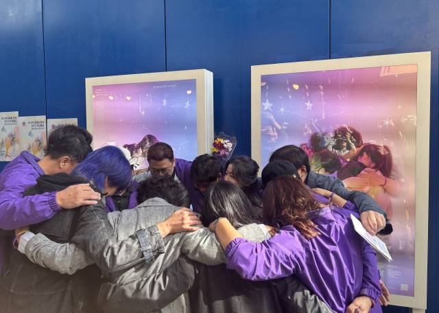 10·29 이태원 참사 3주기를 엿새 앞둔 23일 이태원 참사가 일어났던 이태원역 1번 출구 인근에 전시된 추모 사진 전시 앞에서 유가족들이 서로를 껴안고 있다. 연합뉴스