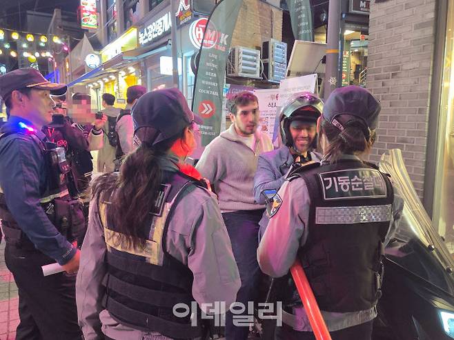 24일 오후 7시 이태원 세계음식문화의 거리에서 기동순찰대원이 헬멧을 착용하지 않은 오토바이 탑승자를 계도하고 있다.(사진=김현재 기자)