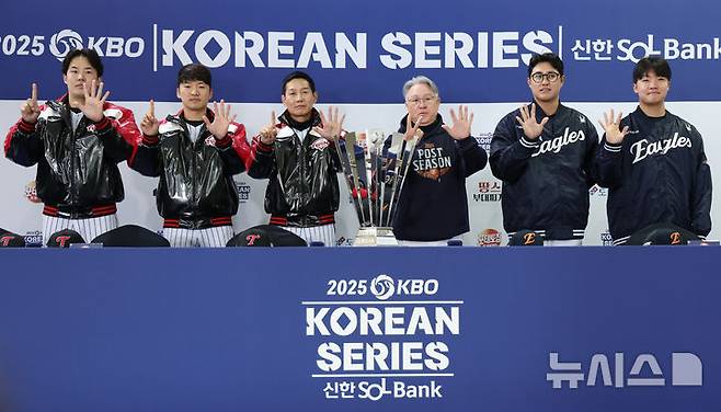 [서울=뉴시스] 김진아 기자 = 염경엽 LG 트윈스 감독과 김경문 한화 이글스 감독을 비롯한 선수들이 25일 서울 잠실야구장에서 열린 2025 KBO 한국시리즈 미디어데이에서 우승 트로피와 기념촬영을 하던 중 손가락으로 몇 차전 경기까지 갈 것인지 표시하고 있다. 왼쪽부터 LG 트윈스 임찬규, 박해민, 염 감독, 한화 이글스 김 감독, 채은성, 정우주. 2025.10.25. bluesoda@newsis.com