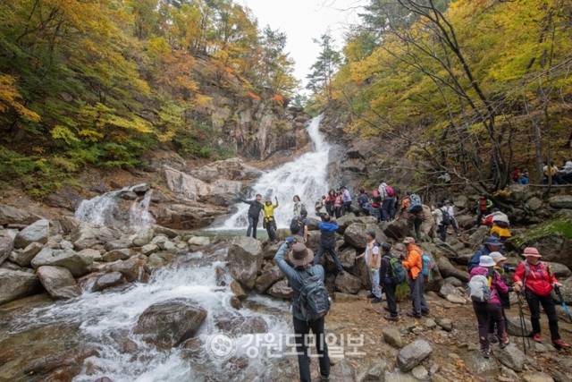 ▲ 울산바위 아래 펼쳐진 비경 말굽폭포를 배경으로 등산객들이 기념사진을 찍고 있다.