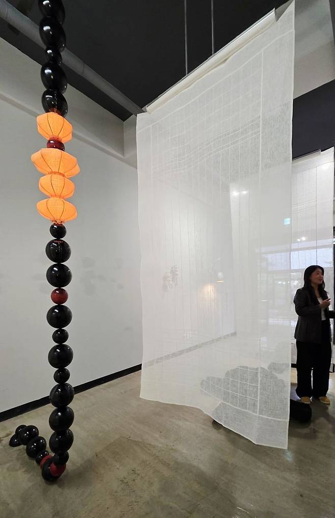 [사진=박현주 미술전문기자]아트파먼트에 참가한 위켄드랩(WKND)전시장은 이하린 전은지 작가의 옻칠 칠보 자개가 어우러진 구슬조명 설치 작품과 삼베로 만든 대형 발 설치물로 주목 받았다. 2025.10.26.hyun@newsis.com *재판매 및 DB 금지