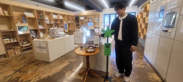 27일 경주 황리단길 청년감성상점에서 만난 김진용 사장이 '비로컬위크' 입간판을 가리키며 포즈를 취하고 있다. 권영진 기자
