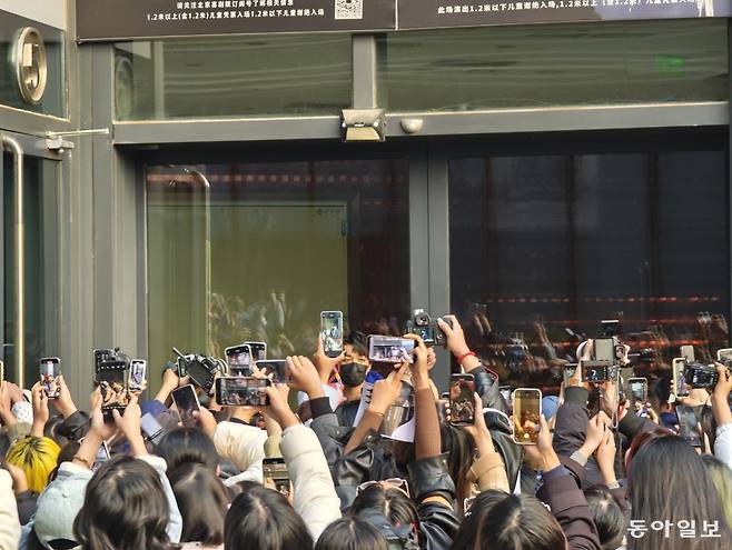25일 한국 창작뮤지컬 ‘광염 소나타’의 라이선스 공연이 끝난 뒤 주연 배우인 왕민후이(王敏輝·가운데 검정 마스크를 쓴 남성)가 건물 밖으로 나와 팬들에게 인사를 건네고 있다. 베이징=김철중 특파원 tnf@donga.com