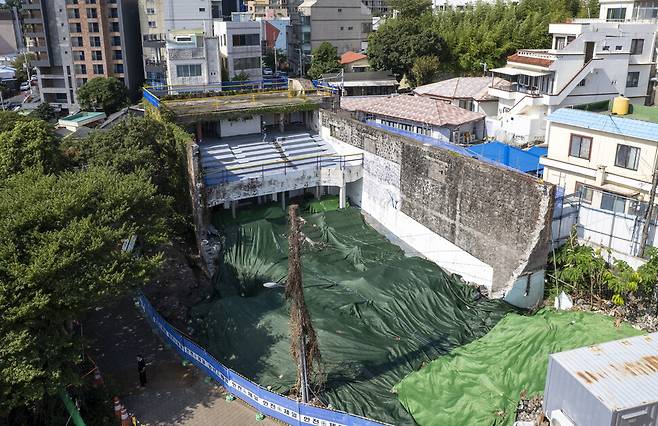 드론으로 찍은 서귀포관광극장의 모습. 극장 관람석 주변 현무암을 쌓아 만든 ㄷ 모양의 외벽에서, ㄴ 모양 벽은 허물어지고 빈터에 방수포가 덮여 있다.
