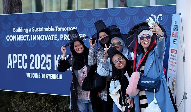 2025 경주 아시아태평양경제협력체(APEC) 정상회의 주간 첫날인 27일 외국인 관광객들이 경북 경주역에 설치된 환영부스에서 갓을 쓴 채 기념촬영을 하고 있다. 뉴시스