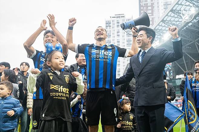 인천 유나이티드 윤정환(오른쪽부터) 감독과 무고사, 이명주가 26일 인천축구전용경기장에서 열린 경남FC전 승리로 K리그2 우승과 K리그1 승격이 확정된 뒤 팬들과 함께 기뻐하고 있다. /사진=인천 유나이티드 제공