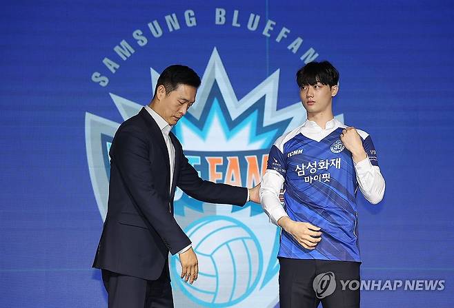 삼성화재 유니폼 입는 이우진 (서울=연합뉴스) 김성민 기자 = 27일 서울 강서구 메이필드 호텔에서 열린 '2025-2026 한국배구연맹(KOVO) 남자 신인선수 드래프트'에서 대전 삼성화재 블루팡스에 1라운드 2순위로 지명을 받은 이우진(오른쪽)이 유니폼을 입고 있다. 2025.10.27 ksm7976@yna.co.kr