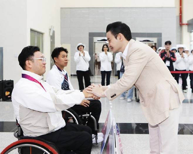 배동현 이사장이 시상식에서 금메달을 획득한 김정남 선수와 악수를 나누고 있다.