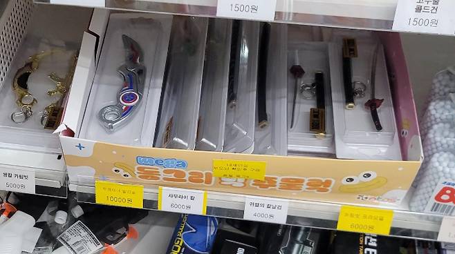 전북 익산의 한 초등학교 앞 무인문구점 매대에 진열된 '사무라이 칼', '귀멸의 칼날 검', '카림빗' 등 금속 재질 장난감 칼 제품들. 보배드림 캡처