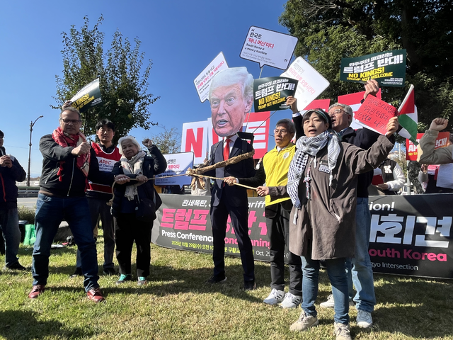 조직위가 기자회견 전 트럼프 탈을 쓴 인물에게 포승중을 묶고 레드카드를 붙이는 퍼포먼스를 진행하고 있다. 김정원 기자