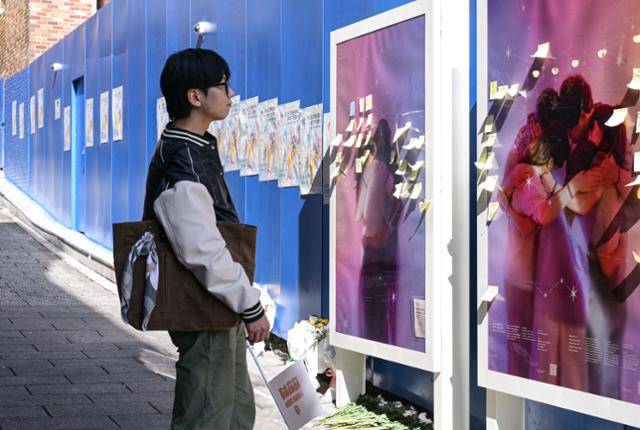 28일 서울 용산구 이태원의 10.29 기억과 안전의 길에서 '이태원을 기억하는 호박랜턴' 활동가 이상민씨가 시민들의 추모글을 읽고 있다. 최주연 기자