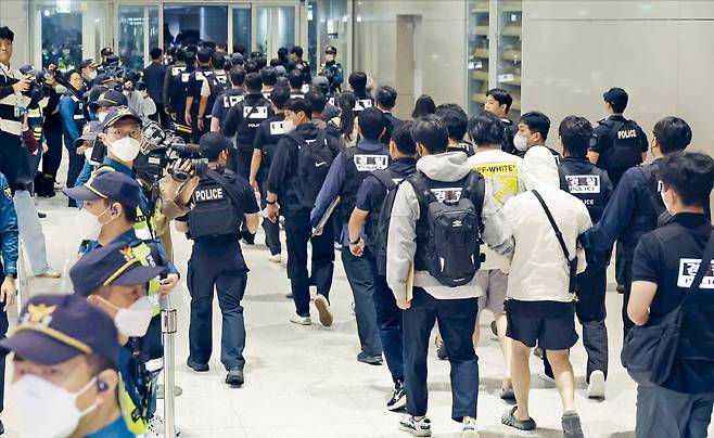 캄보디아 당국에 구금된 한국인 피의자 64명이 지난 18일 오전 인천국제공항 2터미널을 통해 국내로 송환됐다. 이들은 ‘웬치’로 불리는 캄보디아 범죄단지에서 보이스피싱, 로맨스 스캠(사기) 등 범죄에 가담한 혐의를 받는다. 64명 모두 기내에서 체포됐고, 귀국 직후 피의자 신분으로 관할 경찰서에 압송됐다.  /사진=뉴스1