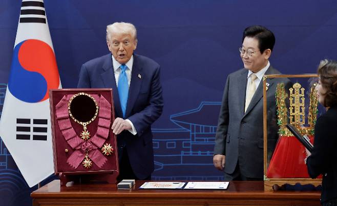 이재명 대통령이 29일 경북 경주박물관에서 도널드 트럼프 미국 대통령에게 '천마총 금관 모형'을 선물하며 설명하고 있다. 왼쪽은 이 대통령이 트럼프 대통령에게 수여한 무궁화 대훈장. 연합뉴스