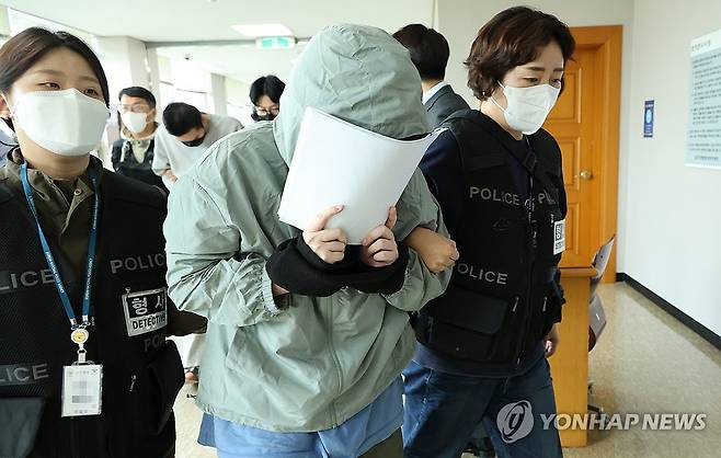 얼굴 가리는 캄보디아 송환 피의자 10월 20일 오후 충남경찰청에서 사기 혐의로 수사받는 캄보디아 송환 피의자들이 충남 홍성 대전지법 홍성지원에 구속 전 피의자 심문(영장실질심사)을 받기 위해 출석하고 있다. [연합뉴스 자료사진]