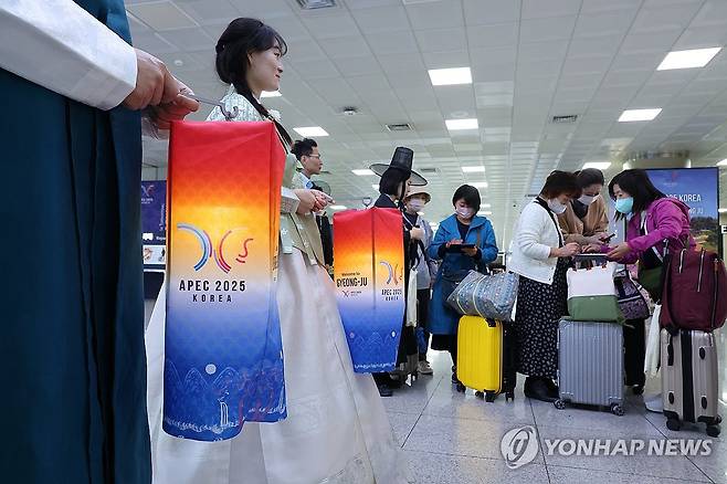 김해공항 APEC 환영 분위기 (부산=연합뉴스) 손형주 기자 = 28일 부산 김해국제공항에 한복을 입은 APEC 환영단이 관광객들을 맞이하고 있다. 2025.10.28 handbrother@yna.co.kr