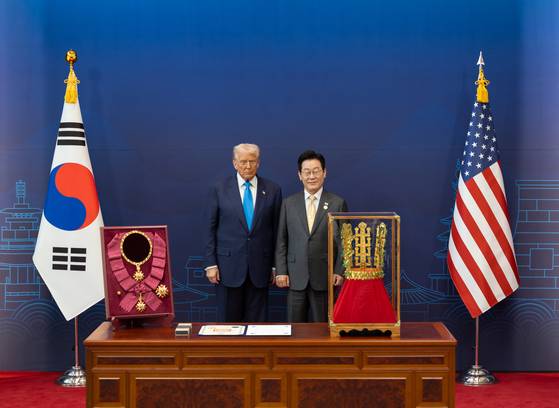 이재명 대통령이 29일 경북 경주박물관에서 열린 한미 공식 환영식에서 도널드 트럼프 미국 대통령에게 무궁화 대훈장 수여와 천마총 금관 모형을 선물하고 있다. 사진 대통령실 제공