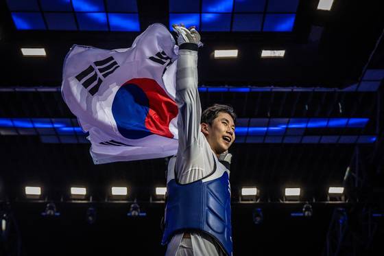 지난 24일 세계태권도선수권대회 남자 87kg 초과급을 제패한 뒤 태극기를 들어보이며 환호하는 강상현. 사진 세계태권도연맹