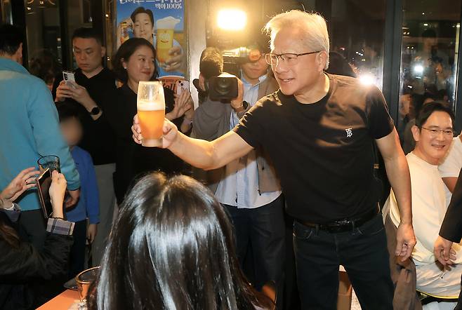 Nvidia CEO Jensen Huang clinks glasses with guests during a fried chicken and beer gathering with Samsung Electronics Chairman Lee Jae-yong and Hyundai Motor Group Executive Chair Chung Euisun at a restaurant in Samseong-dong, Seoul on Thursday. (Pool photo via Yonhap)