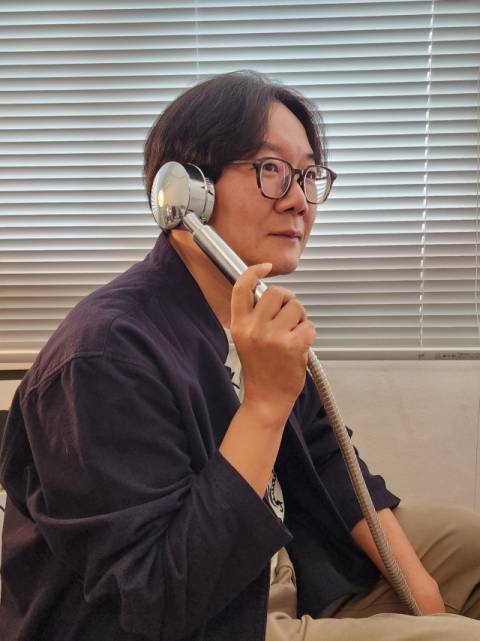 목지수 싸이트브랜딩 대표가 세계 최초의 샤워기형 스피커를 귀에 대고 음악을 듣고 있다.