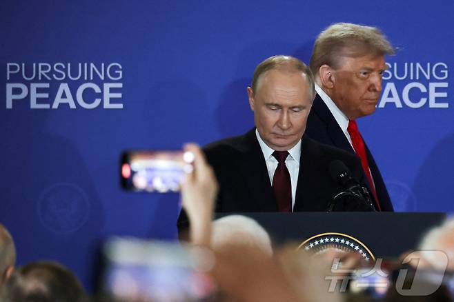 도널드 트럼프 미국 대통령과 블라디미르 푸틴 러시아 대통령이 15일(현지시간) 알래스카 앵커리지의 엘멘도르프-리처드슨 합동 기지에서 우크라이나 전쟁 종식 협상을 위한 회담 후 공동기자회견을 위해 회견장에 입장하고 있다. 2025.08.15. ⓒ 로이터=뉴스1 ⓒ News1 류정민 특파원