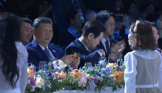 시진핑 중국 국가주석이  31일 경북 경주시 라한셀렉트호텔에서 열린 2025 아시아태평양경제협력체(APEC) 정상회의 환영 만찬에서 어린이 합창단원으로부터 ‘종이 나비’를 선물받고 미소를 보이고 있다.  ‘APEC 2025 KOREA’ 유튜브 갈무리